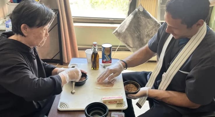 Residents and staff preparing food together in a room
