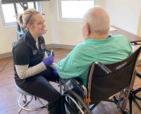 Staff assisting a resident in a facility setting