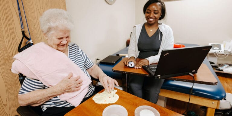 A resident engaged in an activity with staff support