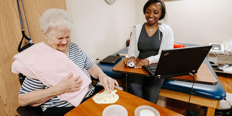 A resident engaged in an activity with staff support