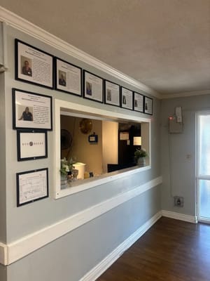 Interior view of a reception area with framed staff photos