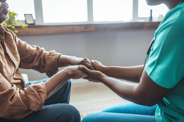 Caregiver holding hands with a senior resident