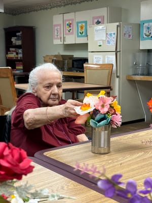 Resident arranging flowers in a common area