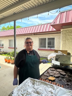 Staff member grilling food outdoors at the facility