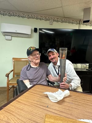 Two men celebrating with a trophy in a common area