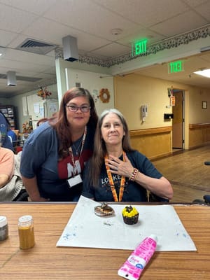 Resident and staff member celebrating with cupcakes