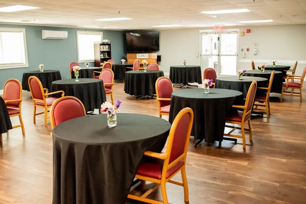 Empty activity room with round tables and flowers