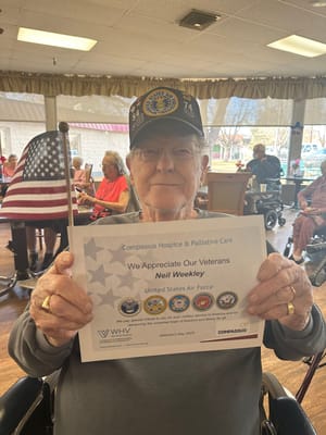 Elderly veteran holding a certificate of appreciation