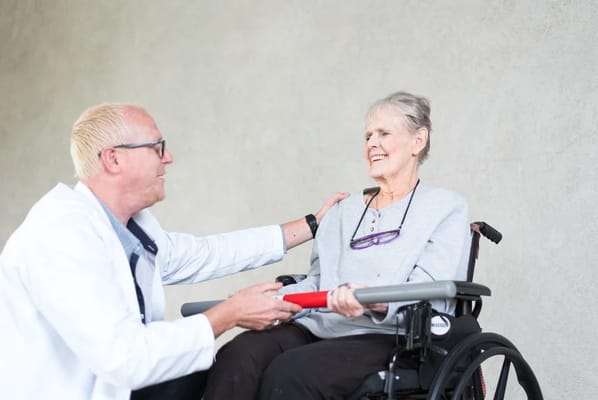 A caregiver assisting a resident in a wheelchair