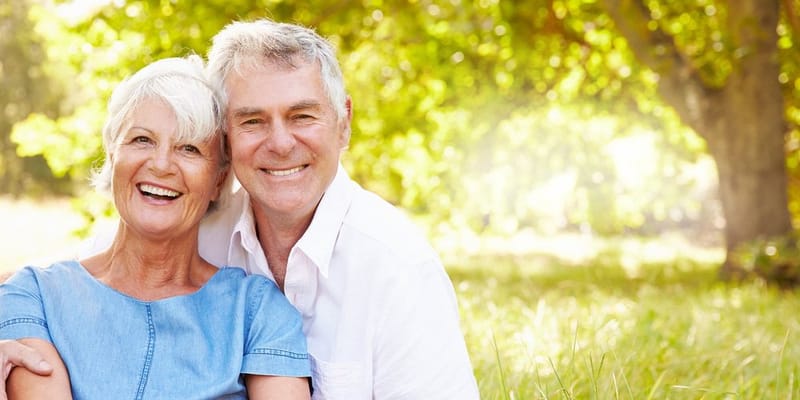 Smiling senior couple sitting together outdoors