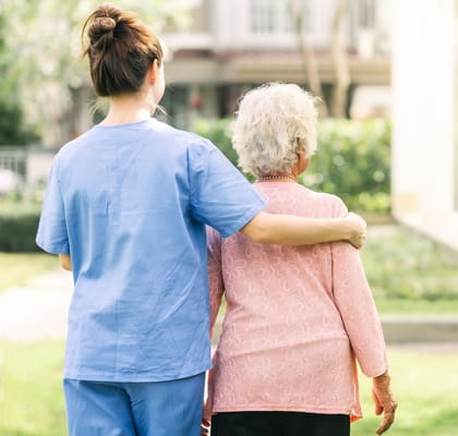 Caregiver with a resident in a garden setting