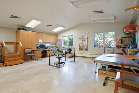 Spacious therapy room with exercise equipment and windows