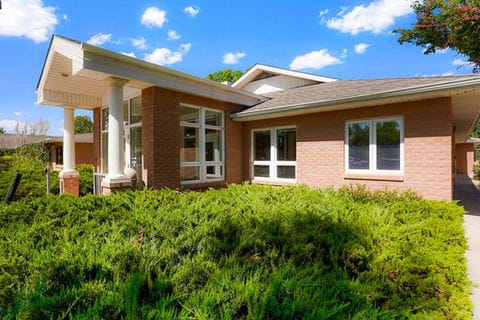 Exterior view of a senior living facility surrounded by greenery