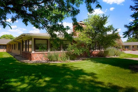 Exterior view of a senior living facility surrounded by greenery