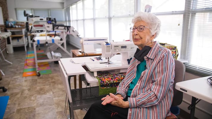 Resident enjoying a sewing activity in a well-lit room