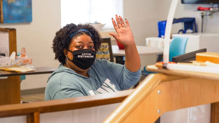 Staff member waving in a common area