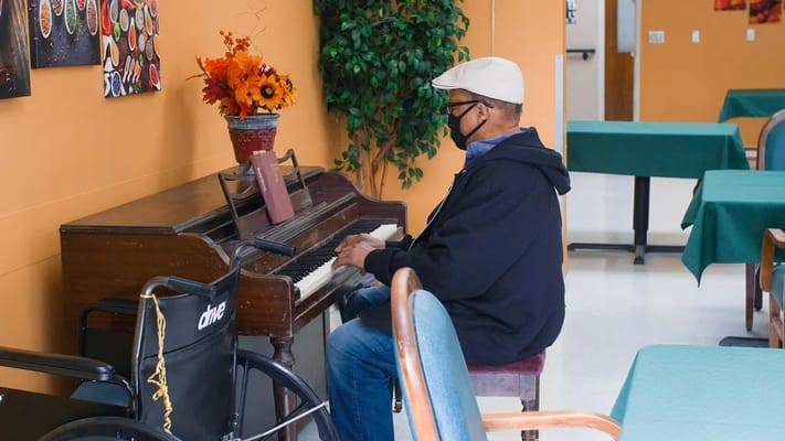 Resident playing piano in a common area