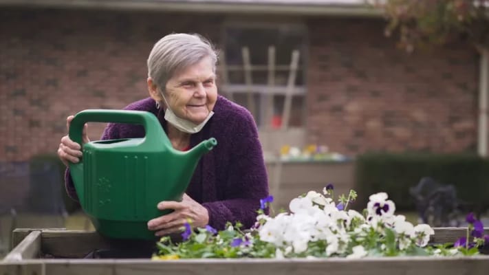 Resident watering flowers in a garden