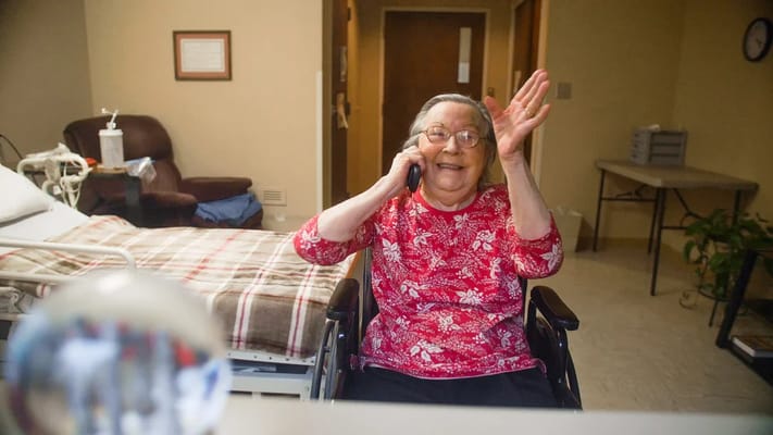 Senior resident talking on the phone in her room