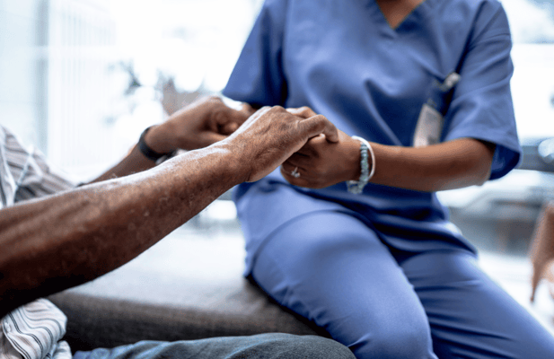 Caregiver holding hands with a resident