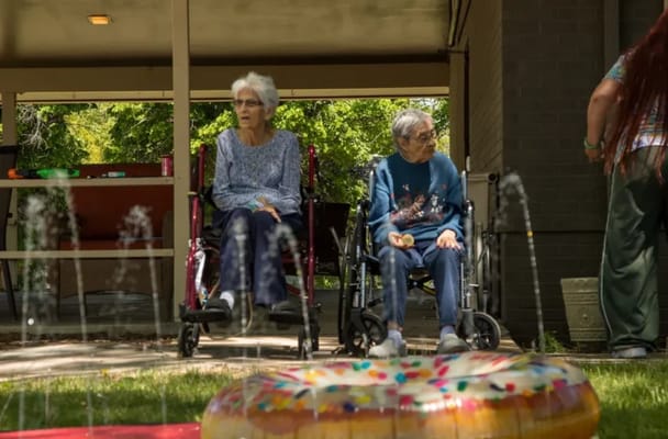 Two residents sitting outdoors in wheelchairs