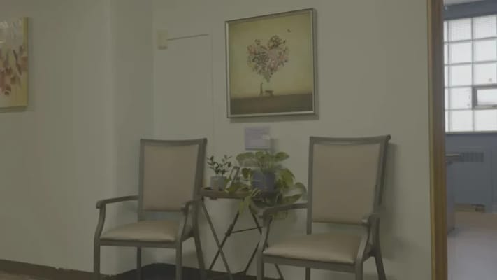 Seating area with plants and artwork in a hallway