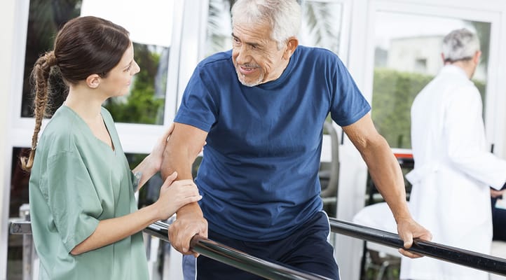 Therapist assisting senior man during rehabilitation session