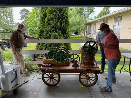 Residents engaging with a vintage machinery display outdoors