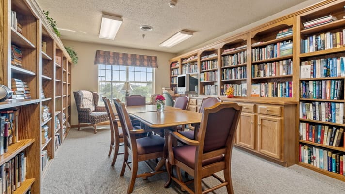 Bright common area with bookshelves and a dining table