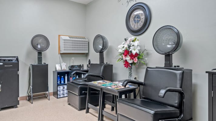 Hair salon area with styling chairs and dryers