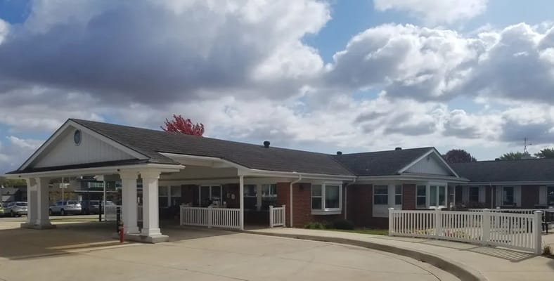 Exterior view of a senior living facility with a covered entrance