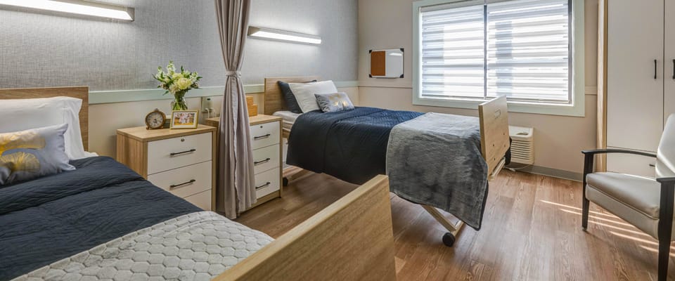 A cozy interior room with two beds and personal items