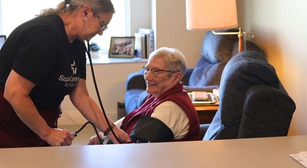 Caregiver checking blood pressure of a resident