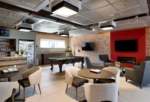 Bright common area with lounge seating and pool table