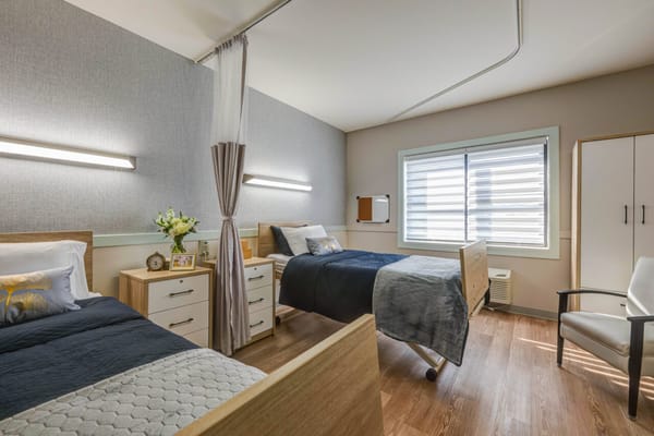 Bright resident room with two beds and modern furnishings