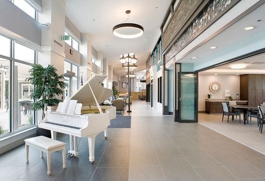 Bright common area with a white grand piano