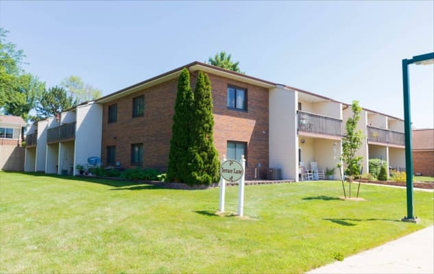 Exterior view of a senior living building with grass