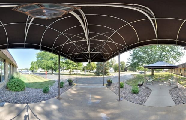 Covered outdoor seating area with path and greenery
