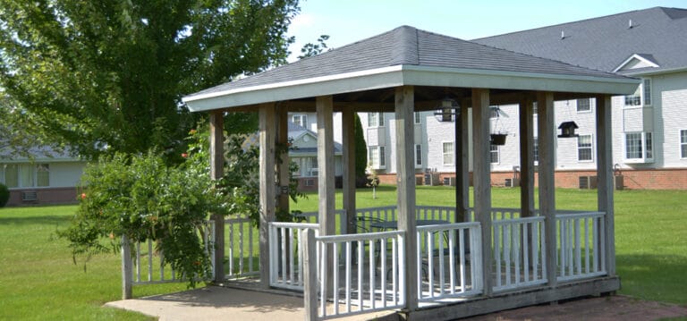 A gazebo in a green outdoor space at a senior living facility