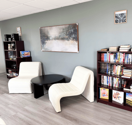 A cozy reading area with white chairs and bookshelves