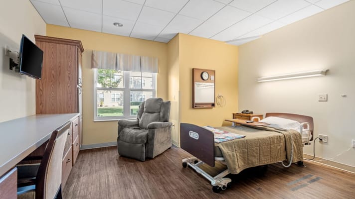 Private resident room with bed and chair