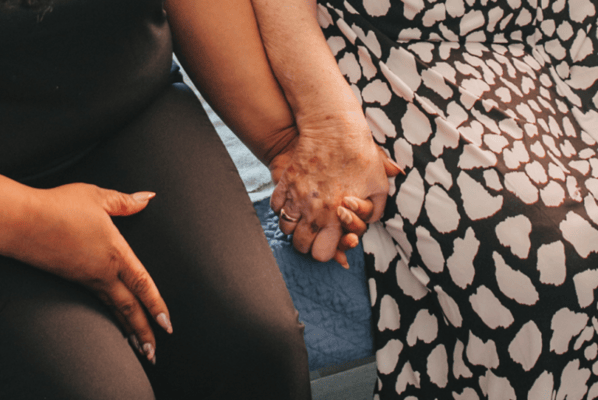 Two individuals holding hands, showing companionship