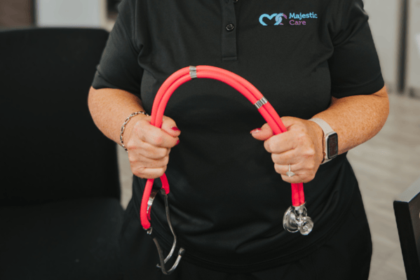Staff member holding a stethoscope with focus on healthcare