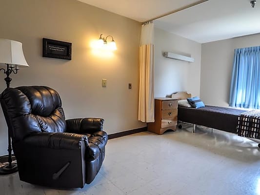 Cozy private resident room with chair and bed