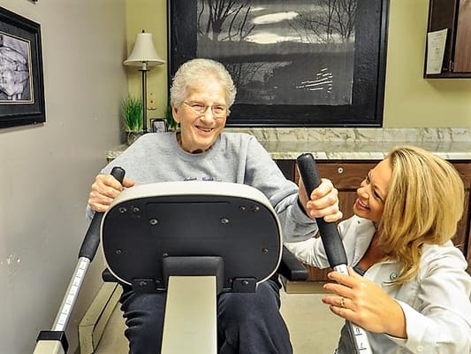 Senior resident exercising with staff support