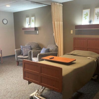 A private resident room with a bed and seating area