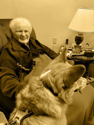 Resident smiling with a dog in a cozy room