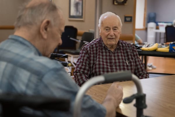 Two seniors conversing at a dining table