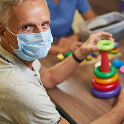 Senior man engaging in an activity with colorful toys