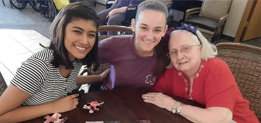 Residents and staff enjoying a puzzle activity together
